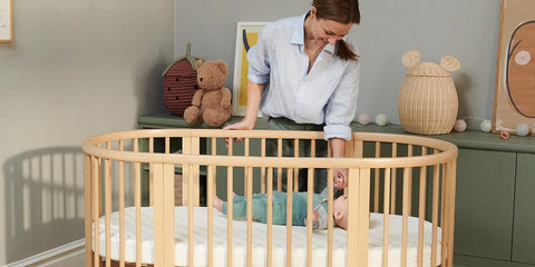 Madre junto a una cuna evolutiva Stokke Sleepi en un dormitorio infantil