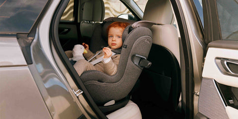 Niño sentado en una silla de coche CYBEX Sirona Ti instalada en el vehículo