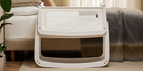 SnüzPod 5 blanca junto a la cama en un dormitorio